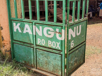 Metal gate painted green, with "KANGUNU" in white letters at the Kangunu Factory in Muranga, Kenya.