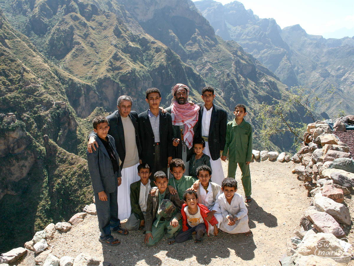 A group poses for a photo on a rocky outcropping in the steep Yemeni coffee lands. This is from a trip to Yemen in 2009.