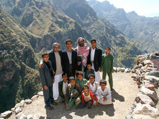 A group poses for a photo on a rocky outcropping in the steep Yemeni coffee lands. This is from a trip to Yemen in 2009.